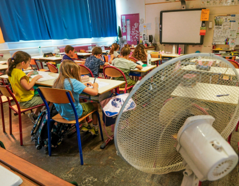 Classe d'école étouffante sous la chaleur avec un ventilateur inefficace